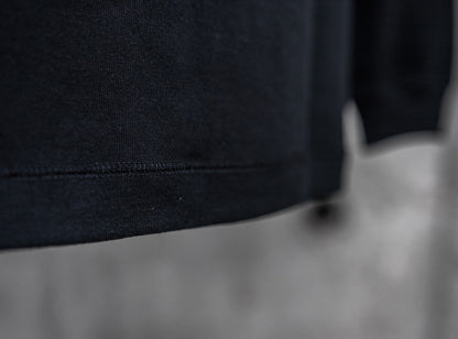 ブラックの新作長袖Tシャツ、裾のクローズアップ。10ozのしっかりとしたヘビーウェイト生地と、耐久性の高いダブルステッチの仕上げ。