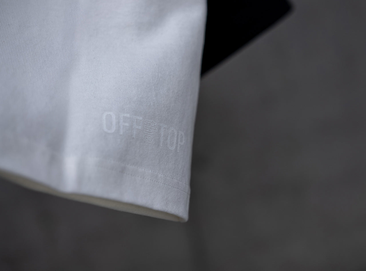 10ozのヘビーウェイトTシャツ、背面右裾に施されたOFF THE TOPのロゴ。ホワイトの生地に同系色のシルクスクリーンプリントを施したミニマルなディテール。