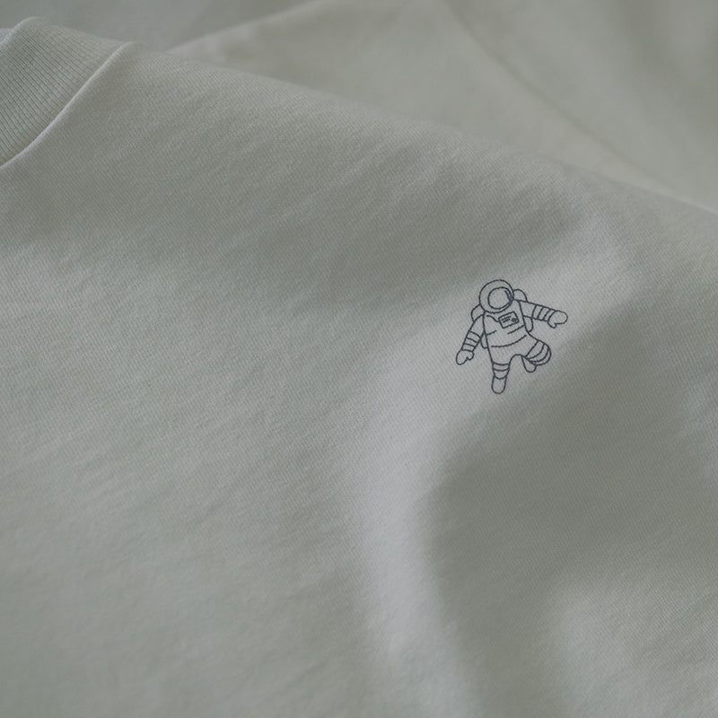 OFF the TOPのホワイトの半袖Tシャツ。左胸部分に、白いラインで描かれた小さな宇宙飛行士のイラストがシルクスクリーンでプリントされています。