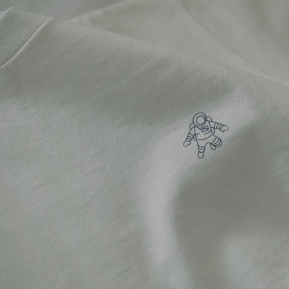 OFF the TOPのホワイトの半袖Tシャツ。左胸部分に、白いラインで描かれた小さな宇宙飛行士のイラストがシルクスクリーンでプリントされています。